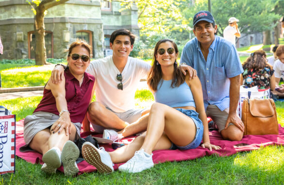 Family of four at the President Provost Welcome Picnic, sitting on a blanket.